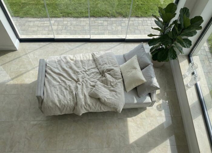 Kadr z góry na pościeloną powierzchnię do spania w salonie sofa Viva